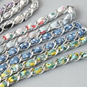 Close-up of stylish chain strap with intertwined floral silk scarves for handbags
