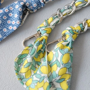 Detail of metal chain strap woven with lemon and blue floral silk scarves for handbags