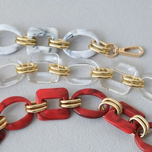 Detail showing acrylic chain straps in marble and transparent styles with gold metal rings