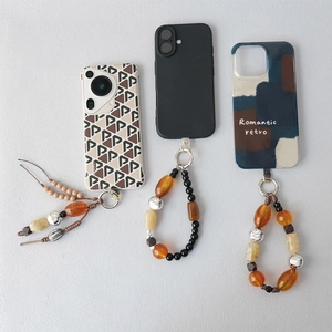 Detailed close-up of acrylic beaded phone straps and patterned cases in retro bohemian style