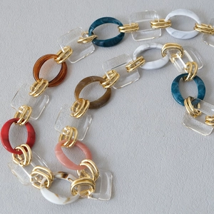 Detail of colorful acrylic resin chain links with gold metal rings for fashion handbags