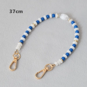 Close-up of 37cm blue and white acrylic beaded strap with golden metal carabiners