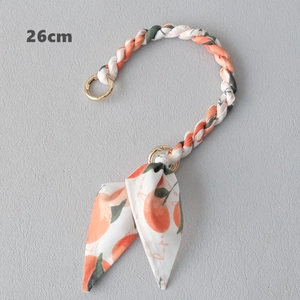 Détail d'une chaîne de sac 26cm en foulard de soie à motif agrumes et boucles d'or