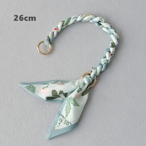 Close-up of a 26cm floral silk scarf bag handle with gold rings and bow detail