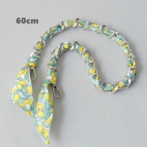 Detail of 60cm silver metal chain intertwined with yellow-green floral silk scarf ribbon