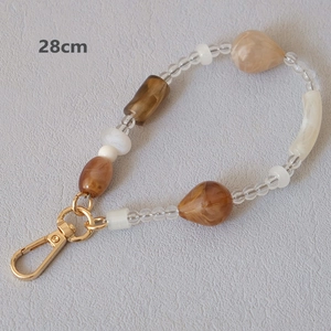 Detailed 28cm view of acrylic beaded strap with amber droplets and golden lobster clasp