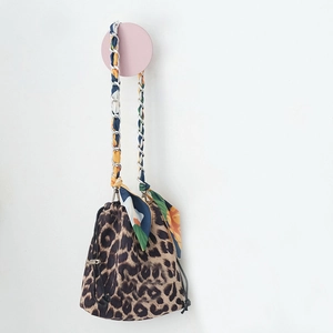Detail of leopard print bucket bag with chain strap and colorful silk scarf handle