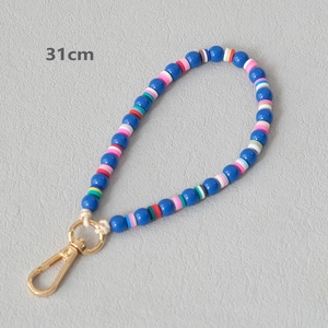 Detail view of 31cm colorful acrylic and heishi bead strap with gold lobster clasp