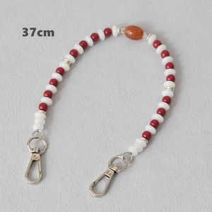 Detail of 37cm beaded chain with red, white, and orange acrylic beads and silver lobster clasps