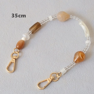 Detail showing a 35cm acrylic bead chain with marble drops and golden lobster clasps