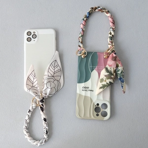 Detail of trendy phone cases with silk scarf handles and colorful floral weaving straps