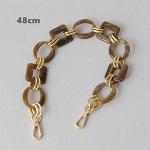 Detail of marble brown resin chain with gold metal links and lobster clasp for handbags