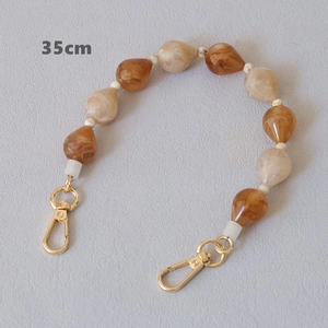Detailed view of 35cm acrylic bead chain with amber water drop beads and gold lobster clasps