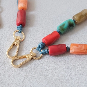 Gros plan détaillé des perles en acrylique colorées et fermoirs dorés pour bandoulière de sac