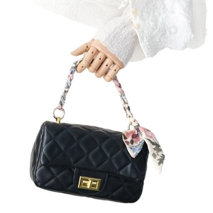 Quilted black leather handbag featuring a gold buckle and floral silk scarf handle