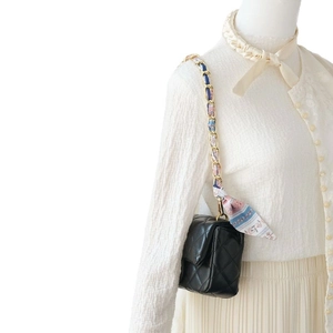 Quilted black leather handbag with gold chain and floral silk scarf strap accessory