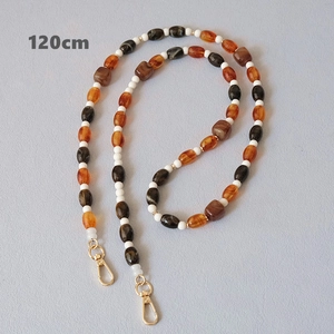 Détail d'une bandoulière en perles acryliques de 120 cm avec fermoirs dorés
