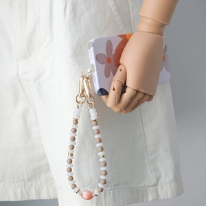 Detail of beaded mobile phone strap with acrylic beads and gold metal clasps