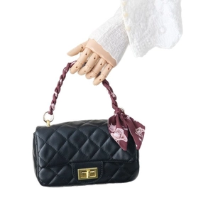 Sac à main en cuir matelassé noir avec fermoir doré et accessoire foulard en soie rose