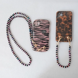 Close-up of candy-colored acrylic beaded phone chain with gold metal hooks on stylish cases