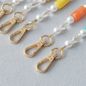 Detail of colorful acrylic bead strap with white pearls and gold metal lobster clasps
