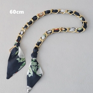 Détail de la chaîne dorée de 60cm entrelacée avec un foulard en soie à fleurs