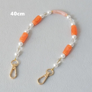 Detail of 40cm orange resin and white pearl beaded chain with golden lobster clasps