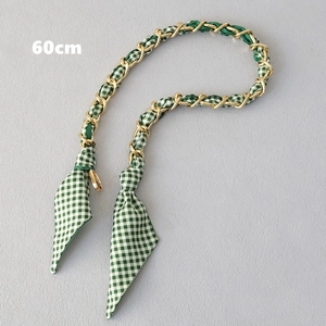 Détail de la bandoulière en tissu à carreaux verts et chaîne dorée de 60cm de long