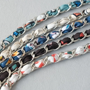 Close-up of five colorful silk scarf woven metal chains for handbag replacement straps