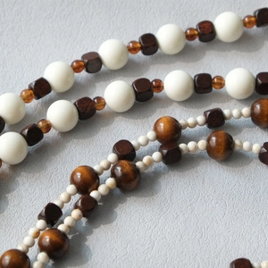 Close-up detail of acrylic and wood beads with vintage texture on a stylish cross-body strap