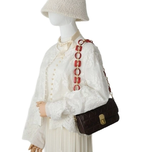 Dark brown quilted shoulder bag with chunky red resin and gold chain strap detail