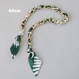 Détail de la bandoulière de 60cm en chaîne dorée et soie fleurie vert foncé à fermoirs