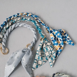 Detail of silk scarf woven bag straps with golden rings and various floral patterns