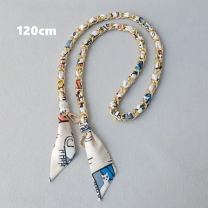 Close-up of a 120cm gold chain strap interwoven with a colorful cartoon silk scarf