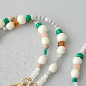 Détail de perles en acrylique colorées et fermoir en métal doré de qualité sur une lanière