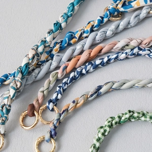 Detail of woven silk scarf handbag chain with polished gold spring buckle