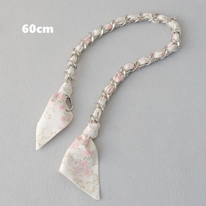 Détail d'une bandoulière de 60cm en chaîne argentée entrelacée de ruban floral rose