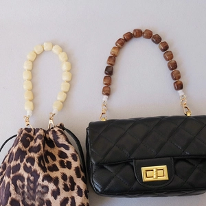 Close-up of leopard drawstring bag and black quilted pouch with chunky resin bead handles