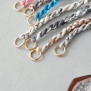 Detail of woven silk scarf handbag chains with premium gold metal rings in various patterns