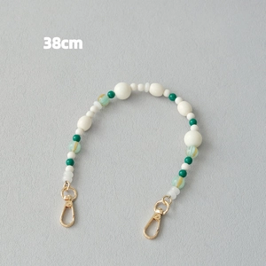 Détail de la lanière en perles acryliques de 38cm avec perles vertes et fermoir doré