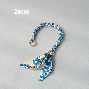 Close-up of 26cm floral silk scarf bag handle strap with polished gold metal clasps