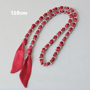 Close-up of a 120cm red silk scarf interwoven with silver metal chain strap for bags