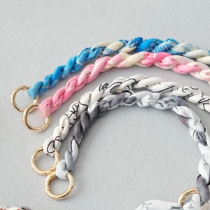 Detail of silk scarf wrapped handbag chain straps with premium gold metal spring rings