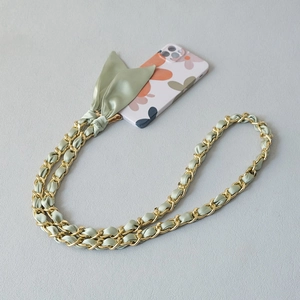 Light green silk scarf interwoven with gold chain phone strap featuring a decorative bow