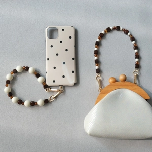 Detail of beaded crossbody phone chain with wooden beads and pearlescent mini bag