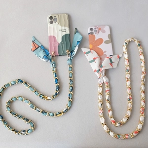 Detail of crossbody phone cases with floral patterns and silk scarf metal chain straps