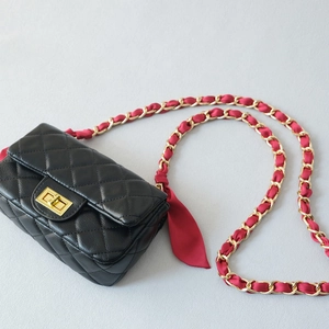 Classic black quilted crossbody bag with golden twist lock and red silk woven chain strap