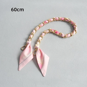 Détail d'une bandoulière de 60 cm en chaîne dorée et foulard en soie rose à fleurs