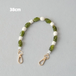 Détail de la chaîne de 38cm avec perles en résine marbrée verte et fermoirs dorés