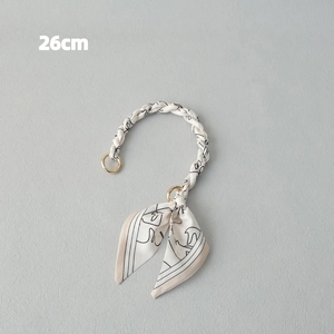Detail of 26cm scarf-wrapped handbag chain handle with gold rings and abstract print